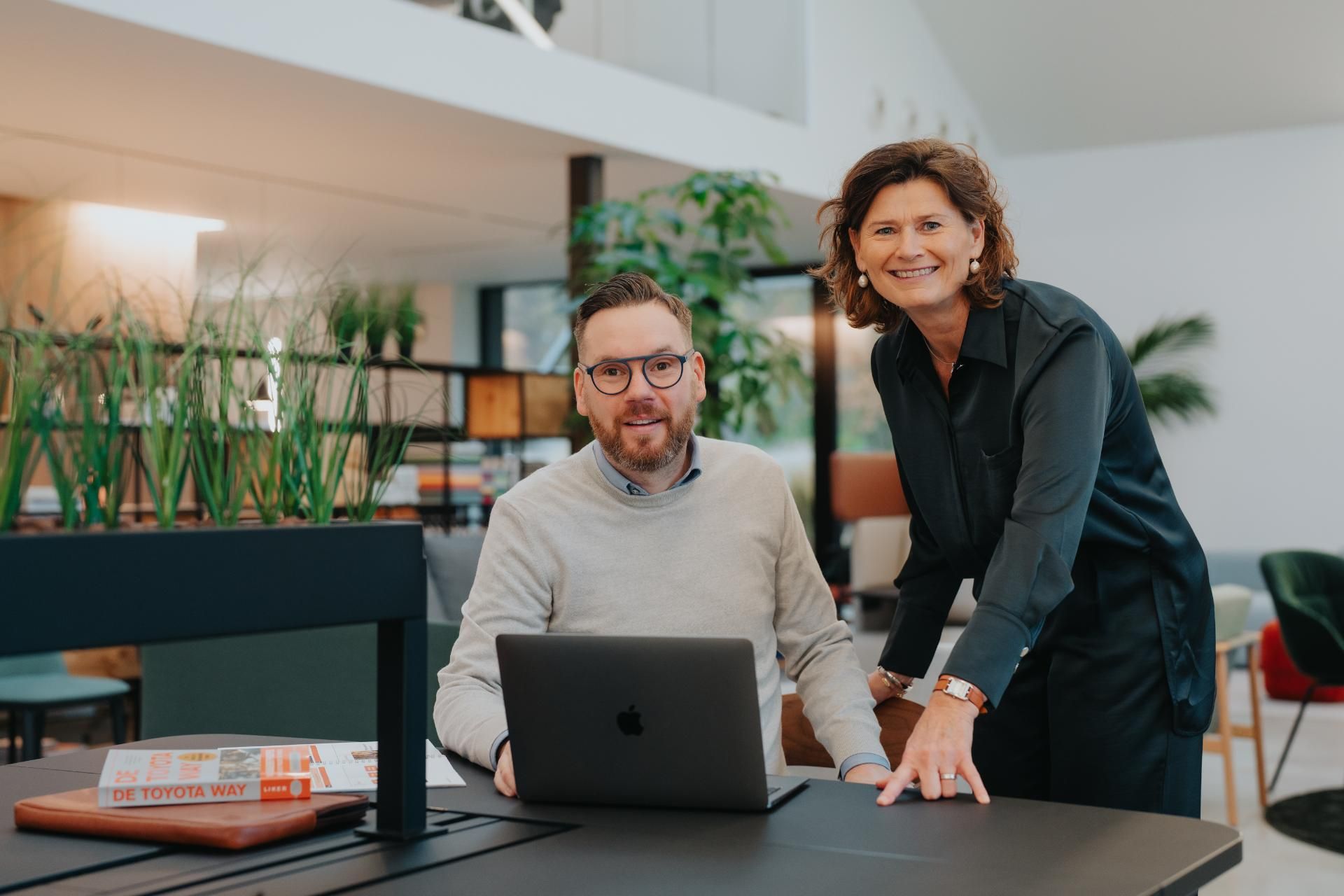 Twee coaches die samenwerken achter laptop tijdens overleg 